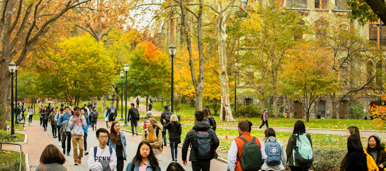 Students walking on Penn Campus Locust Walk in the fall.