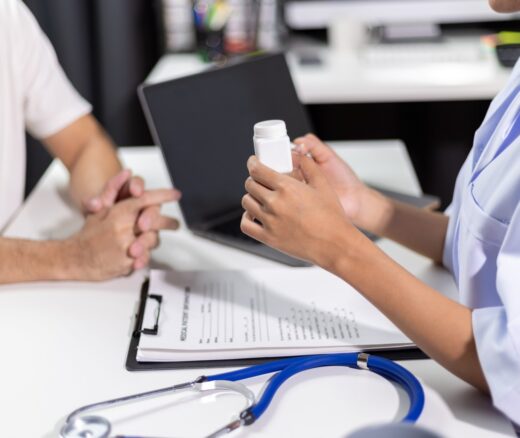 Doctor and patient meeting, doctor holding bottle of medication