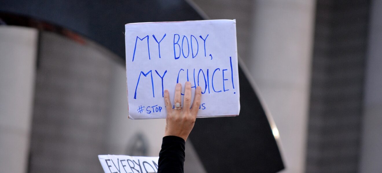 A person holding a sign that says "my body, my choice!"