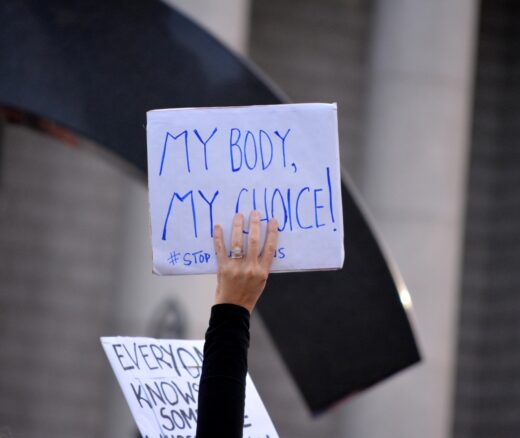 A person holding a sign that says "my body, my choice!"