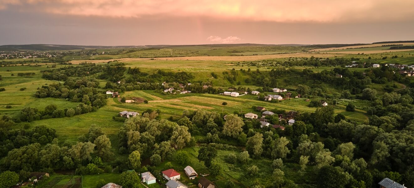 Aerial view of residential houses in suburban rural area at sunset.