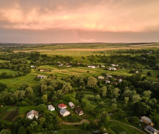 Aerial view of residential houses in suburban rural area at sunset.