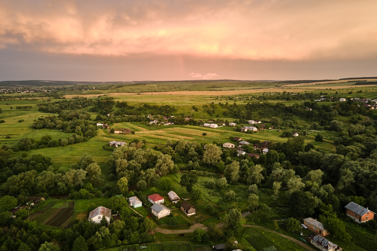 Aerial view of residential houses in suburban rural area at sunset.