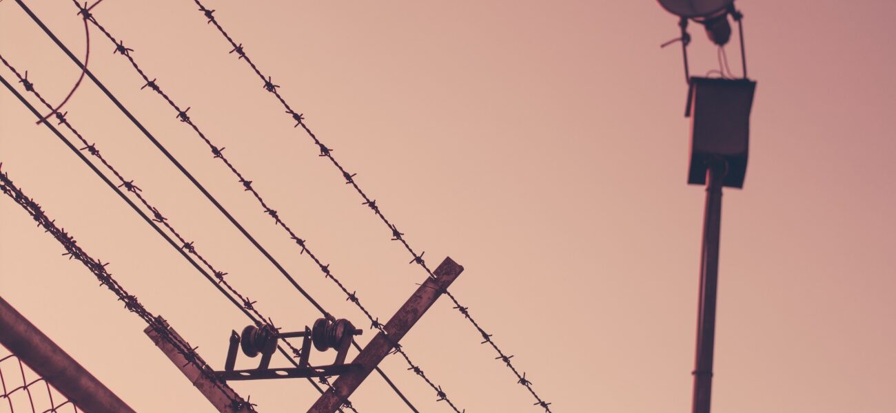 Barbed wire above a fence at a detention facility.