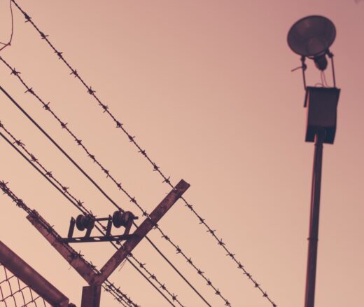 Barbed wire above a fence at a detention facility.
