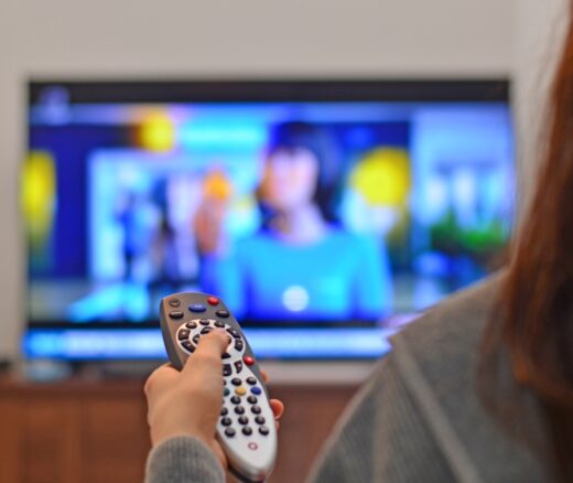 Woman watching tv and using remote controller.