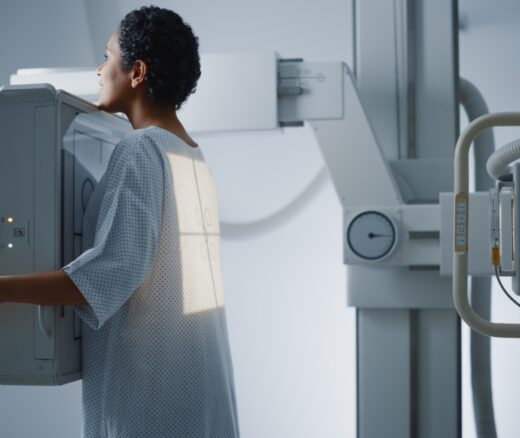 A woman with short, curly black hair receiving an X-ray.