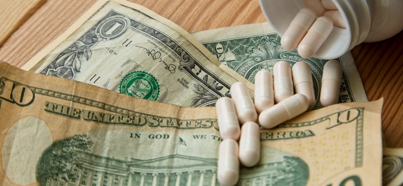 Prescription medication pills from a bottle on a $10 bill.