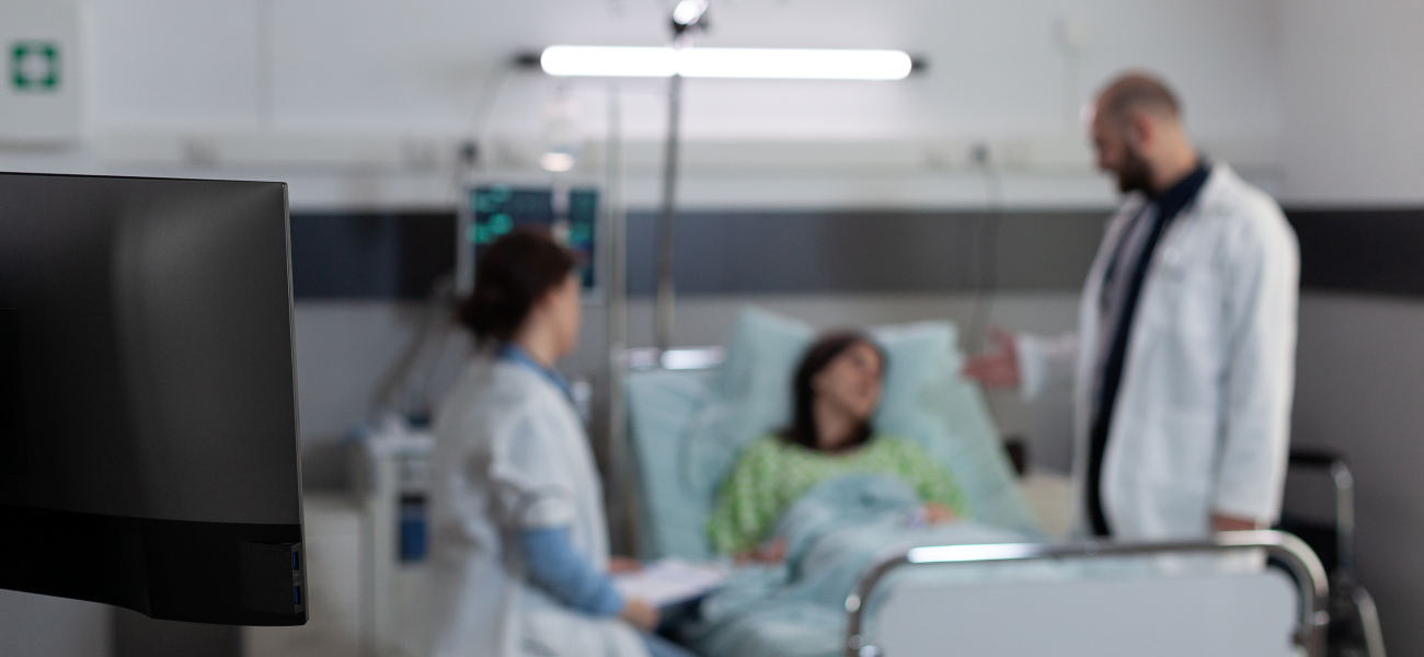 Nurse and doctor in the blurred background with a desktop computer in focus.