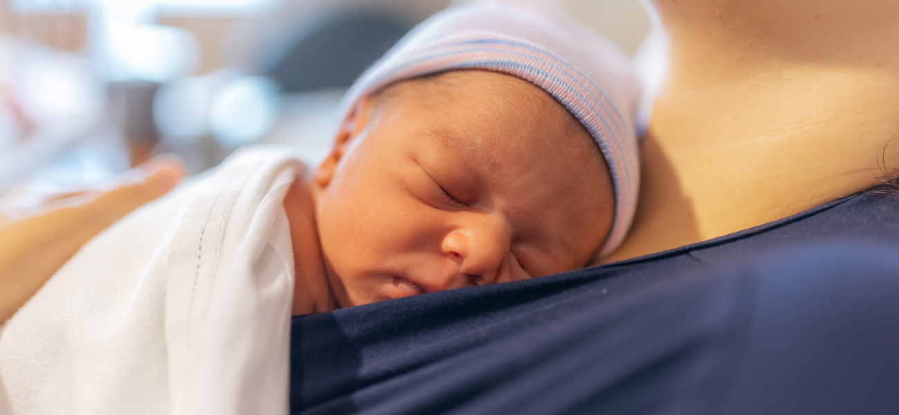 A newborn infant resting on their mother's chest.