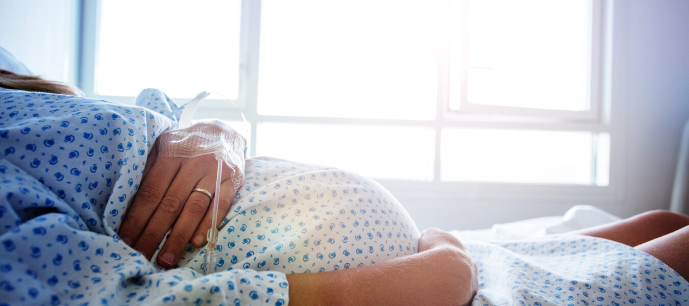A pregnant person in a hospital bed