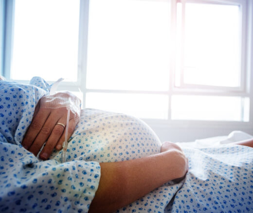A pregnant person in a hospital bed