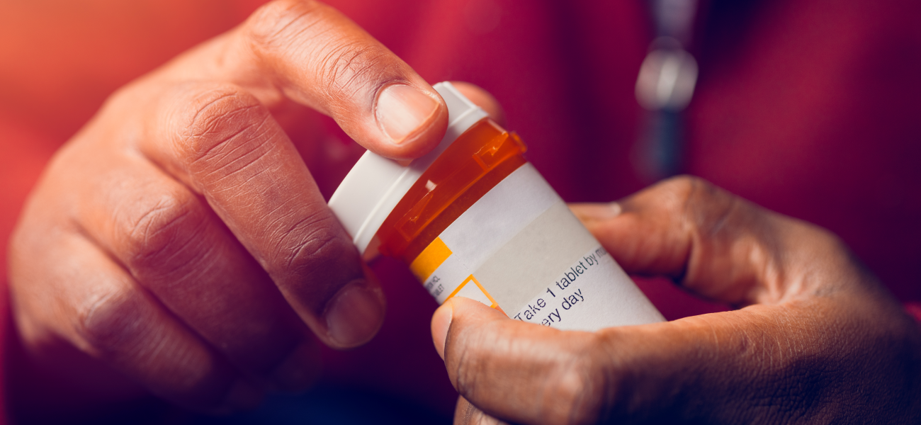 An individual holding a medication bottle.