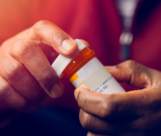 An individual holding a medication bottle.