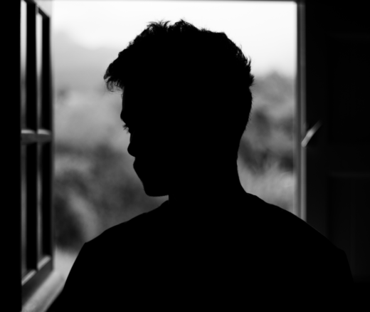 A man's black silhouette at the window, in black and white.