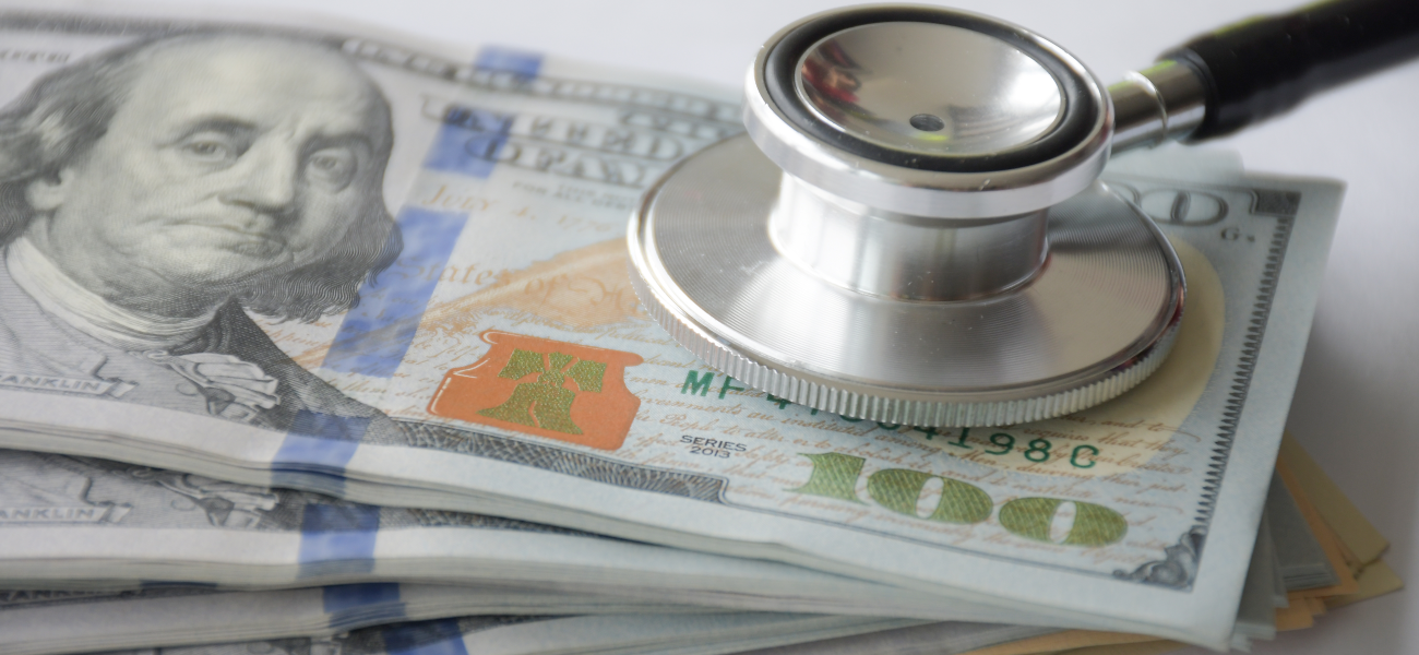 A stethoscope placed on top of cash