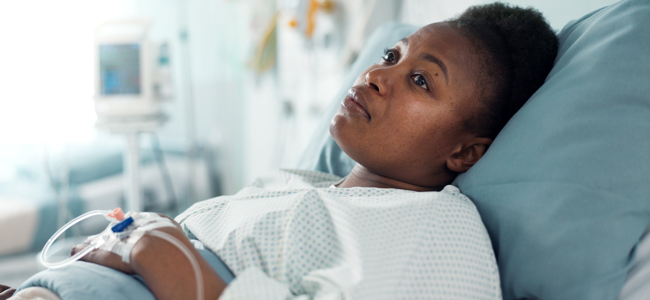 A Black woman laying in a hospital bed.