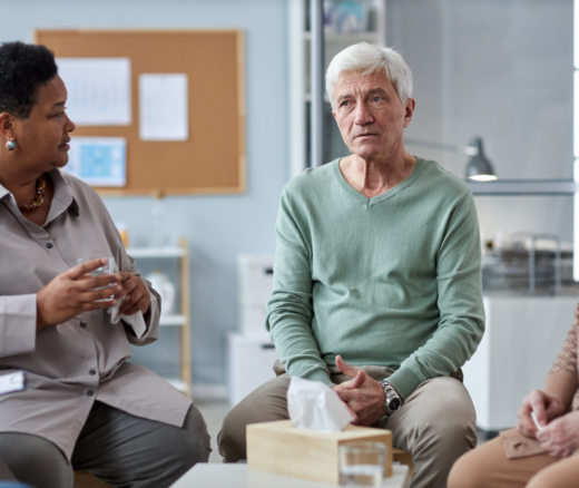 A Black woman and a white man participating in a group discussion
