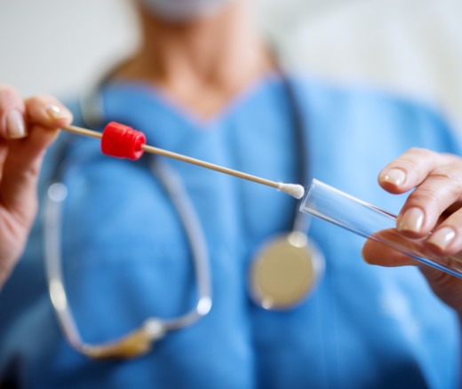A nurse adding a sample to a test tube